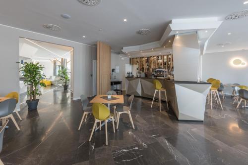 a restaurant with yellow chairs and tables in a room at Hesperia Hotel & Residence in Lido di Jesolo