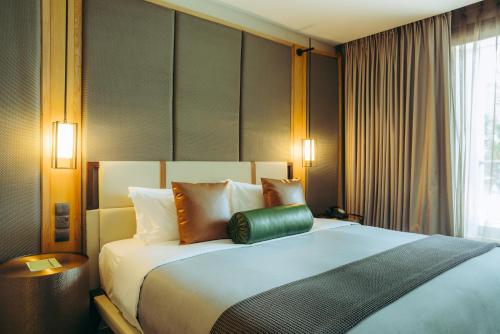 a bedroom with a large bed with a green pillow on it at The Social House Nairobi, a Preferred Lifestyle Hotel in Nairobi