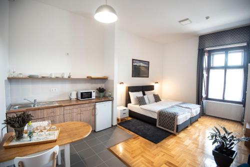a kitchen and a living room with a bed and a table at Grossmann Ház in Mád