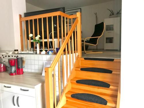 - un escalier en bois dans une cuisine avec un comptoir dans l'établissement Ferienwohnungen Marita, à Salzwedel