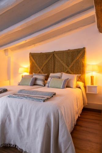 a bedroom with a large white bed with two lamps at Ca la Casilda in Prades