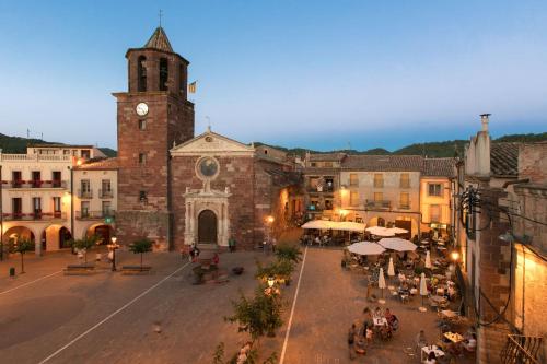 an old building with a church with a clock tower at Ca la Casilda in Prades