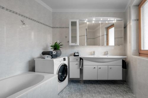 a white bathroom with a washing machine and a sink at DACIASA Apartment in San Vigilio Di Marebbe
