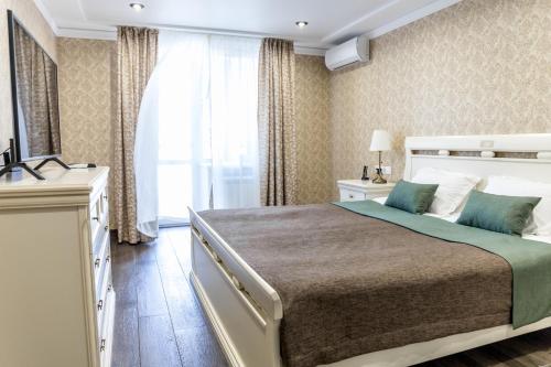 a bedroom with a large bed and a window at Boutique Hotel Russkaya Okhota in Samara