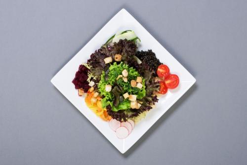 a white plate of food with vegetables on it at Kloster Dornach / Basel in Dornach