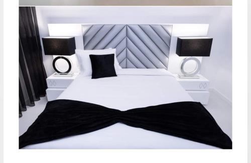 a bedroom with a white bed with a black bow tie on it at Central Apartment in Pombal in Pombal