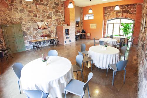 a room with tables and chairs and a stone wall at Eistvere Manor Accommodation in Eistvere