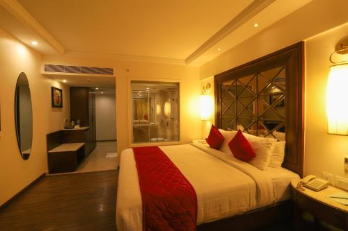 a bedroom with a large bed with red pillows at The Saibaba Hotel in Chennai