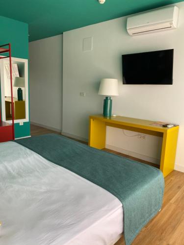 a bedroom with a bed and a tv on the wall at Hotel Ritual Maspalomas - Adults Only in Playa del Ingles