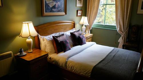 1 dormitorio con 1 cama con almohadas y 2 lámparas en The King Alfred Pub, en Winchester