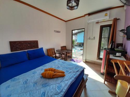 een slaapkamer met een bed met blauwe lakens en een tafel bij Runa Runa The Best Samed Island in Ko Samed