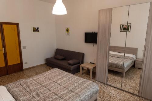 a bedroom with a bed and a chair and a mirror at Poggio del Sole Guest House in Arezzo