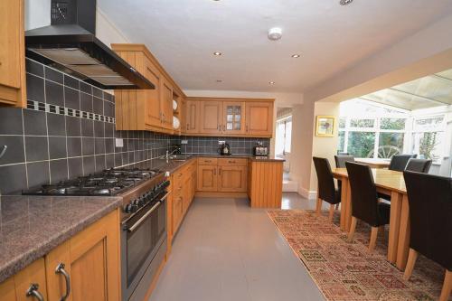 a kitchen with wooden cabinets and a stove top oven at Kings House in Beaumaris