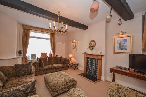 a living room with a couch and a fireplace at Kings House in Beaumaris