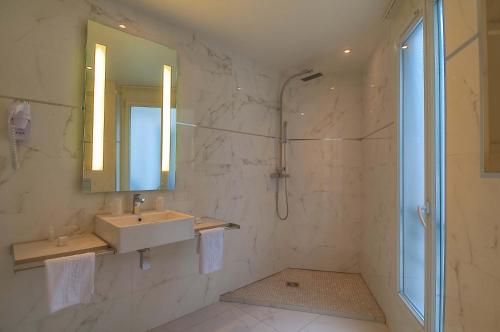 a bathroom with a sink and a shower at Hotel de L'Empereur by Malone in Paris