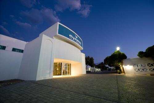 a white building with a sign on it at night at Club Mykonos Langebaan in Langebaan