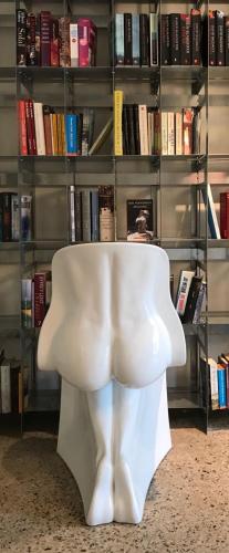 a white chair sitting in front of a book shelf at Hotel Napoleonschuur in Amerongen
