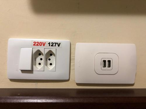 two electrical switches are on a wall at Dom Pedro I Palace Hotel in Foz do Iguaçu