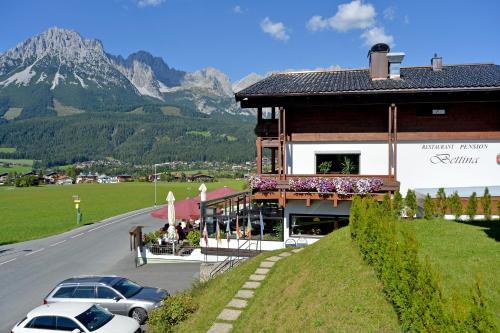 a building with cars parked on the side of a road at Café-Restaurant Bettina in Ellmau