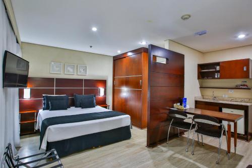 a hotel room with a bed and a desk and a television at Transamerica Executive Chácara Santo Antônio in São Paulo