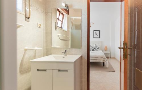 een witte badkamer met een wastafel en een spiegel bij Zambujeira do Mar 4-Bed House Perfect for Families & Friends in Zambujeira do Mar