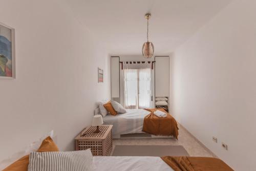 um quarto branco com 2 camas e uma janela em Zambujeira do Mar 4-Bed House Perfect for Families & Friends na Zambujeira do Mar