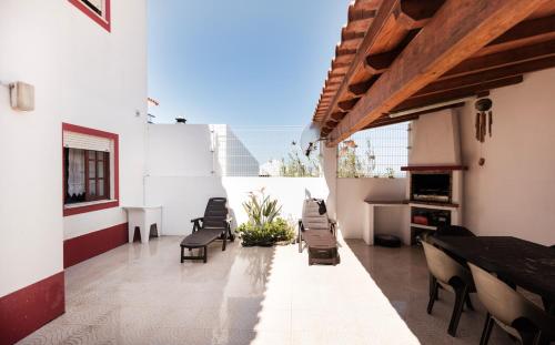 an outdoor patio with chairs and a fireplace at Villa Zambujeira do Mar Family & Friends in Zambujeira do Mar