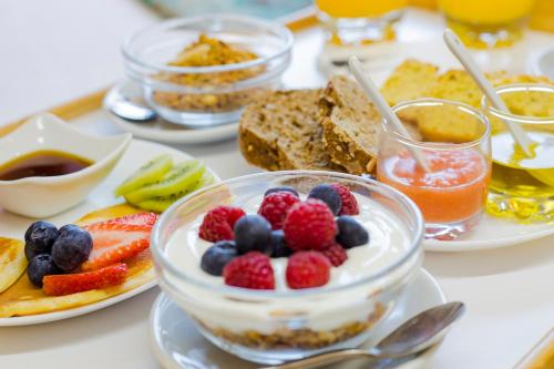 a table topped with a bowl of fruit and bread at Hotel Arce in Baiona