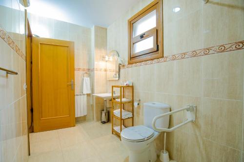 a bathroom with a toilet and a window in it at Hotel Arce in Baiona