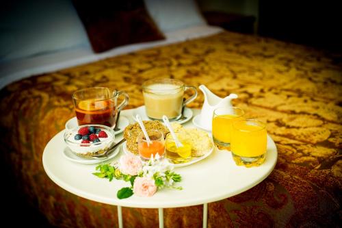 a tray of breakfast foods and drinks on a bed at Hotel Arce in Baiona