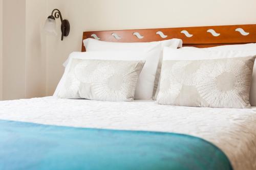 a bed with white pillows and a wooden headboard at Hotel Arce in Baiona