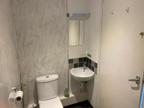 a small bathroom with a toilet and a sink at Cairn House in Ilfracombe