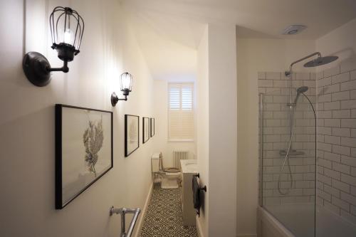 y baño con ducha, aseo y lavamanos. en Beach house no2 with amazing sea views and private garden onto beach., en Fairlie