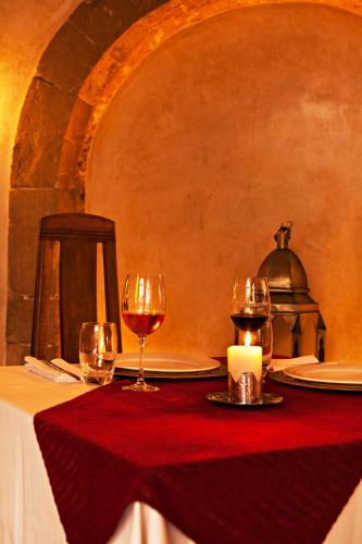 a table with two glasses of wine and a candle at Riad Chbanate in Essaouira