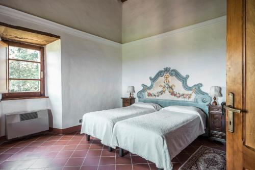 
a bedroom with a large bed and a large window at Castel Pietraio in Monteriggioni
