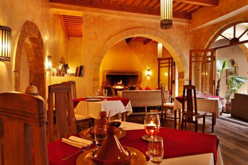 a restaurant with tables and chairs in a room at Riad Chbanate in Essaouira