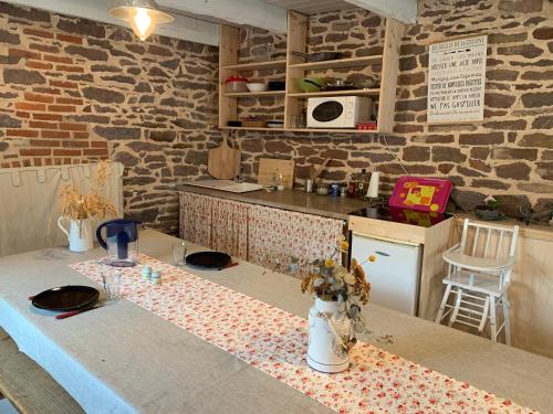 Les Bouyeres في Saint-Malon-sur-Mel: مطبخ مع طاولة عليها قطعة قماش