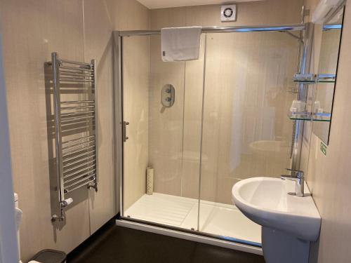 a bathroom with a shower and a sink at Cairn House in Ilfracombe