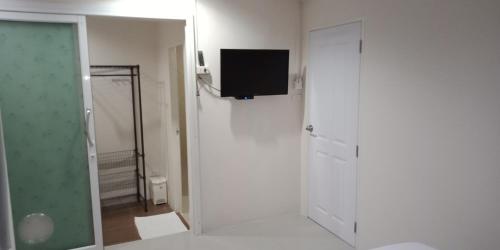 a white room with a television on a wall at เคทู เกสเฮาส์ (K2 Guesthouse) in Chon Buri