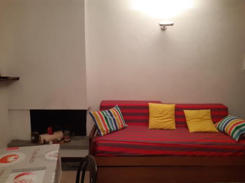 a red couch with yellow pillows in a living room at Jackson in Sauze di Cesana