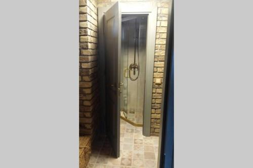 ein Bad mit einer Dusche und einer Glastür in der Unterkunft Mėnulės pirtelė in Sudeikiai