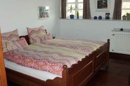 a bed with a blanket on it in a bedroom at Ferienwohnung Haumannshof in Xanten