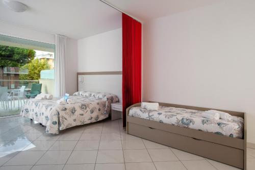 a bedroom with two beds and a window at Residence I Diamanti - Siroli Collection in Cervia