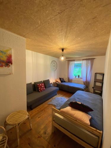 a living room with a bed and a couch at Domek Przy Stoku - Słotwiny in Krynica Zdrój