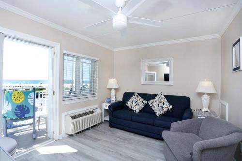 a living room with a blue couch and a chair at Marquis De Lafayette in Cape May