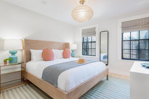 a bedroom with a large bed and two windows at Nantucket Resort Collection in Nantucket