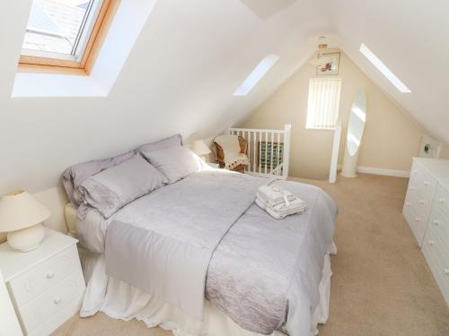 a white bedroom with a bed and a crib at Ffau'r Ddraig in Llanelli