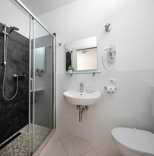 a white bathroom with a sink and a shower at Residence I Diamanti - Siroli Collection in Cervia