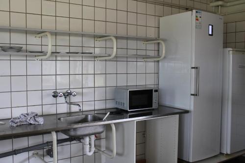 a kitchen with a sink and a refrigerator at Danhostel Aalborg in Aalborg