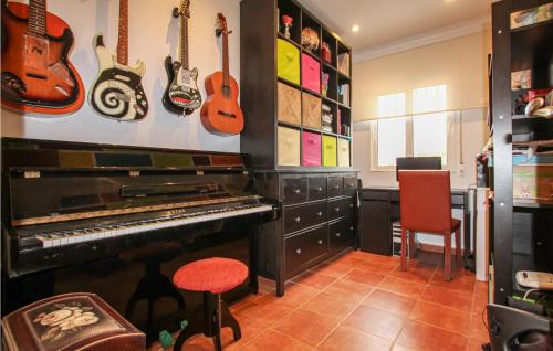 a room with a piano and guitars on the wall at Cozy Home In Orihuela in Orihuela